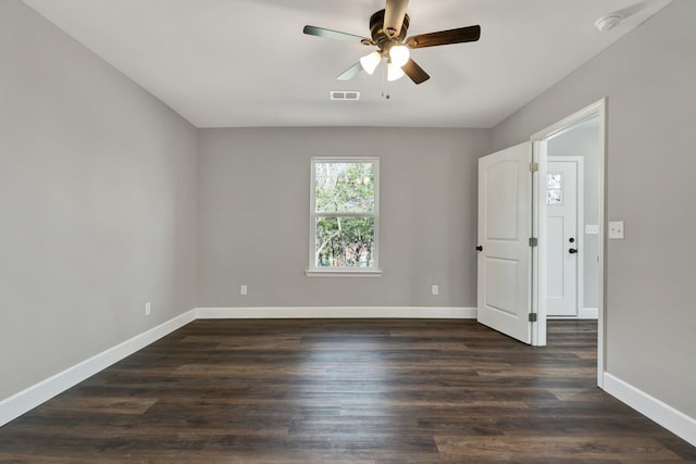 empty room with ceiling fan and dark hardwood / wood-style floors