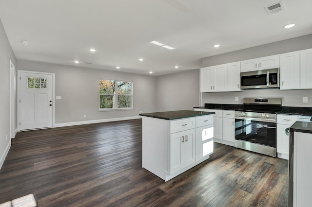 kitchen with white cabinets, stainless steel appliances, and dark hardwood / wood-style floors