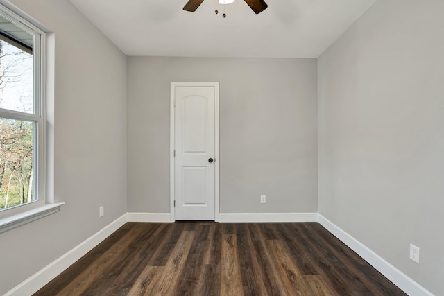 empty room with dark hardwood / wood-style flooring and ceiling fan