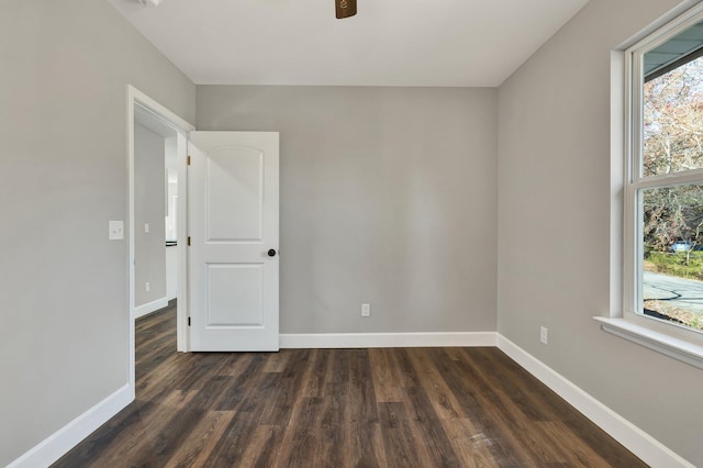 spare room featuring a wealth of natural light and dark wood-type flooring