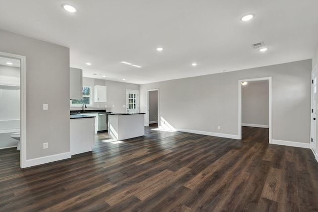 unfurnished living room with dark wood-type flooring and sink