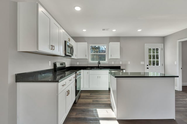 kitchen with stainless steel appliances, white cabinetry, and a healthy amount of sunlight