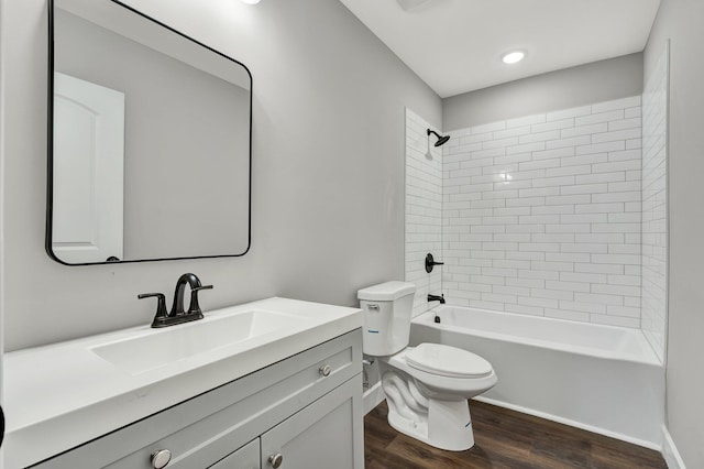 full bathroom with hardwood / wood-style floors, vanity, tiled shower / bath combo, and toilet