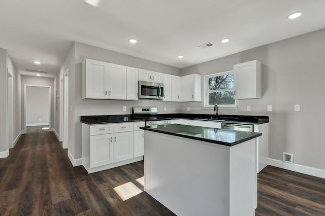 kitchen with white cabinets, a center island, and stainless steel appliances