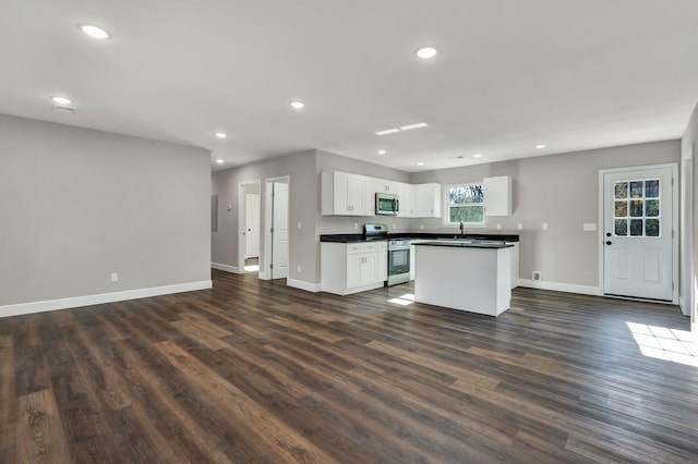 kitchen with white cabinetry, a center island, dark hardwood / wood-style floors, and appliances with stainless steel finishes