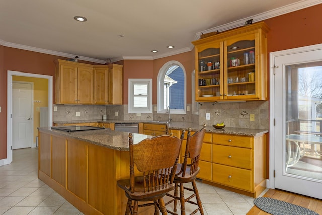 kitchen featuring crown molding, a breakfast bar area, dishwasher, stone counters, and decorative backsplash