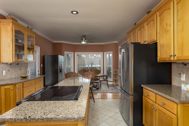 kitchen with range, crown molding, light stone countertops, and stainless steel refrigerator with ice dispenser