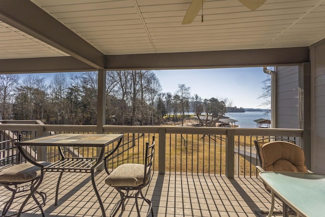 wooden terrace featuring a water view and ceiling fan