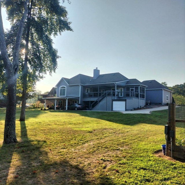 rear view of property with a sunroom and a lawn