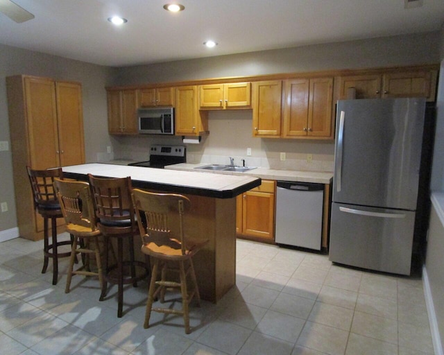 kitchen with sink, a breakfast bar area, and stainless steel appliances