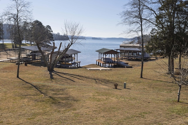 dock area with a water view and a yard