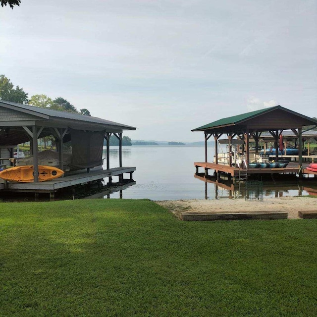 view of dock with a yard and a water view