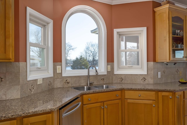 kitchen with sink, stainless steel dishwasher, backsplash, and light stone counters