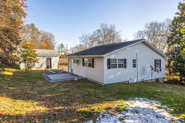 back of property with a patio area, an outbuilding, and a yard