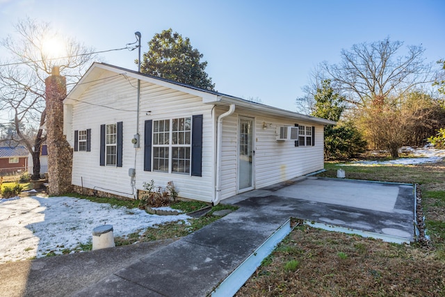 view of property exterior featuring a patio area and an AC wall unit