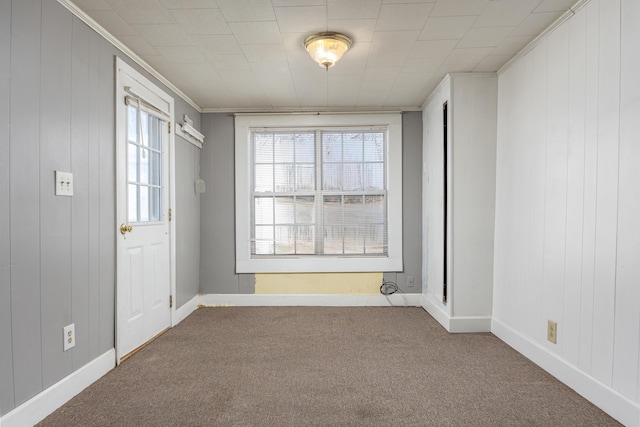 empty room featuring carpet and crown molding