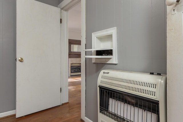 interior details with heating unit and hardwood / wood-style floors