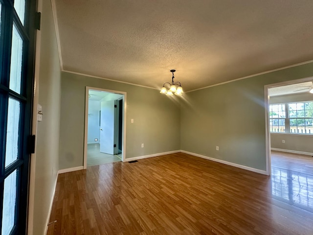 175 Sunset Estates Ln, Dayton, TN 37321 - empty room featuring ornamental molding, dark wood-type flooring, a chandelier, a textured ceiling, and baseboards