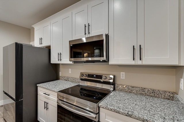 4470 Keith St NW Unit 501, Cleveland, TN 37312 - kitchen featuring appliances with stainless steel finishes, white cabinetry, light stone counters, and wood finished floors
