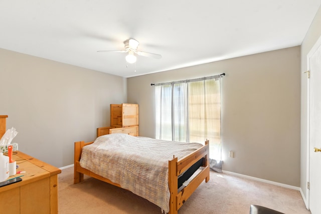 bedroom with baseboards, ceiling fan, and light carpet