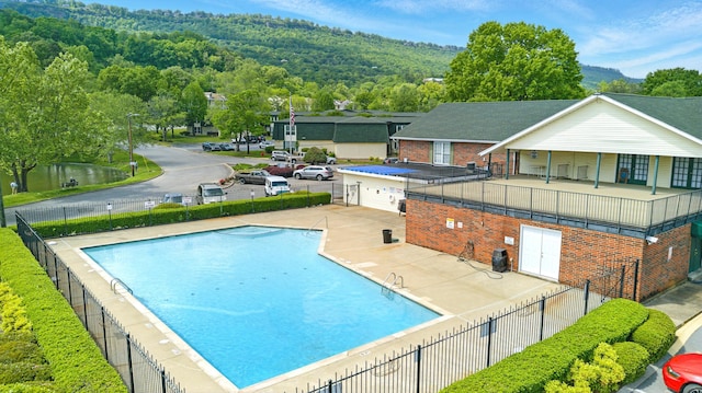 community pool featuring fence and a patio area
