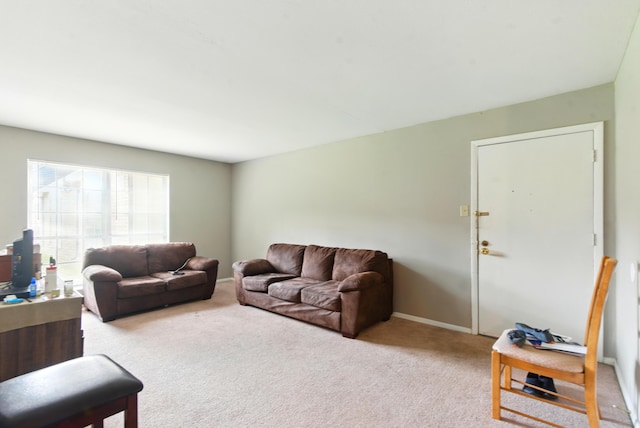 carpeted living room featuring baseboards