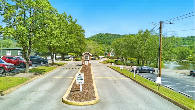 view of road featuring traffic signs, street lights, and curbs
