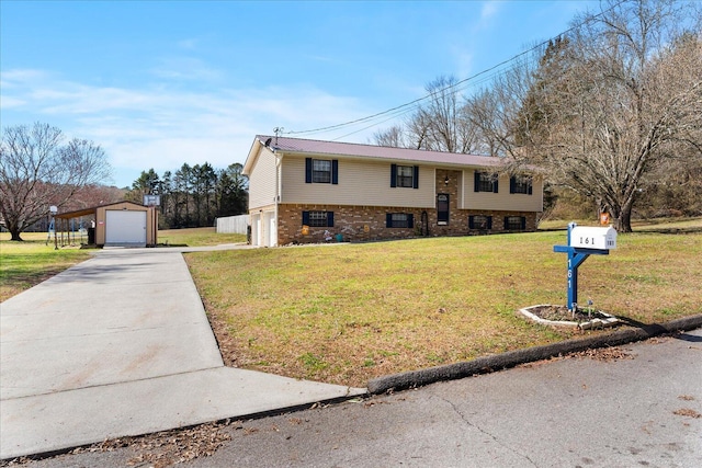 raised ranch featuring an outdoor structure, concrete driveway, a front yard, and metal roof