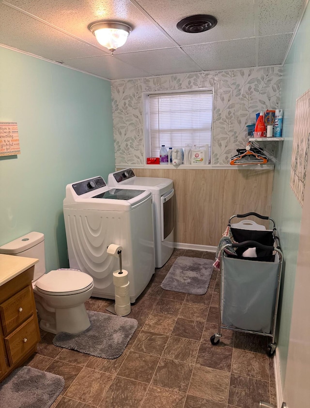 washroom with separate washer and dryer, laundry area, and wallpapered walls