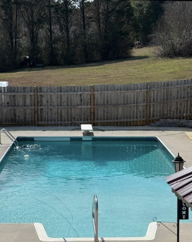 view of pool with a fenced in pool, a lawn, a fenced backyard, and a diving board