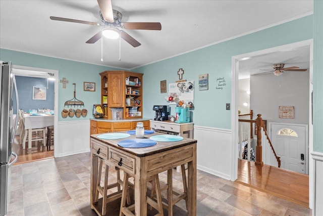 dining area with a wainscoted wall and ornamental molding