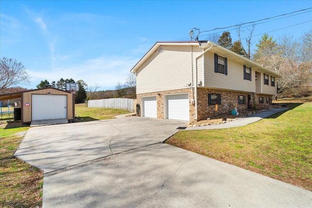 view of side of home with brick siding, a garage, driveway, and a yard