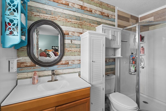 full bathroom featuring vanity, a shower stall, toilet, and a textured ceiling