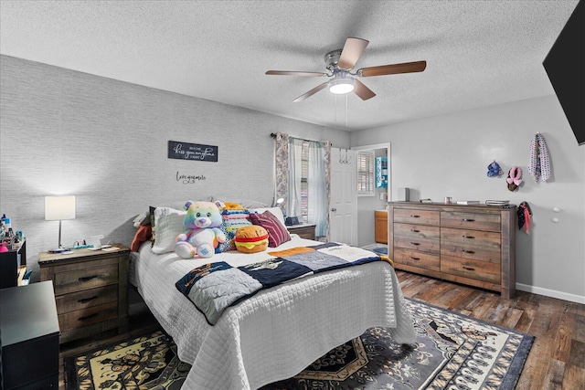 bedroom featuring ceiling fan, baseboards, a textured ceiling, and wood finished floors