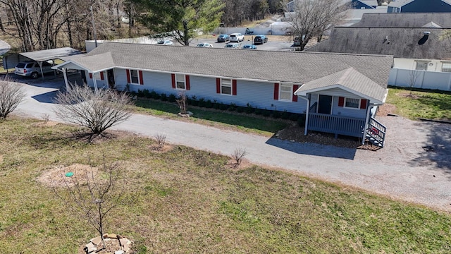 view of front facade featuring a carport, a front yard, and dirt driveway