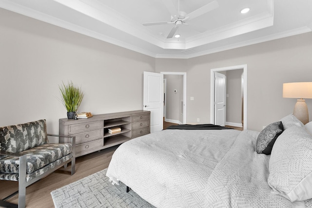 bedroom featuring a ceiling fan, wood finished floors, recessed lighting, crown molding, and a raised ceiling