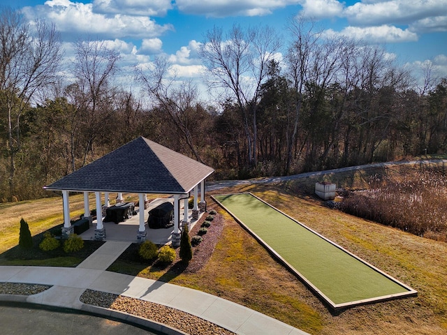 surrounding community with a gazebo, a yard, and a forest view