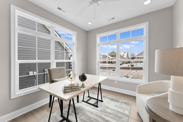 home office with plenty of natural light, a ceiling fan, light wood-type flooring, and baseboards