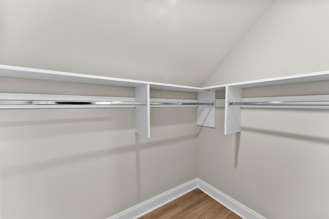 spacious closet with lofted ceiling and wood finished floors