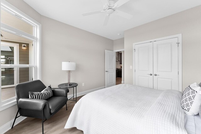 bedroom featuring a closet, ceiling fan, baseboards, and wood finished floors