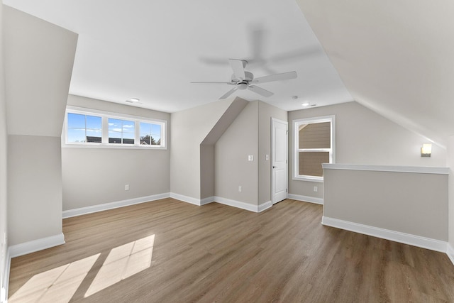 bonus room with a ceiling fan, wood finished floors, and baseboards