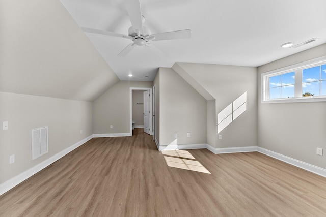additional living space featuring baseboards, visible vents, light wood finished floors, and ceiling fan