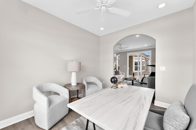 office space featuring baseboards, ceiling fan, recessed lighting, wood finished floors, and arched walkways