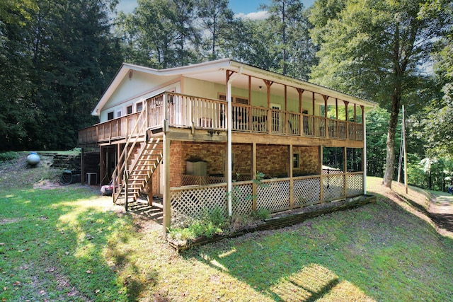 rear view of property featuring a lawn and a wooden deck