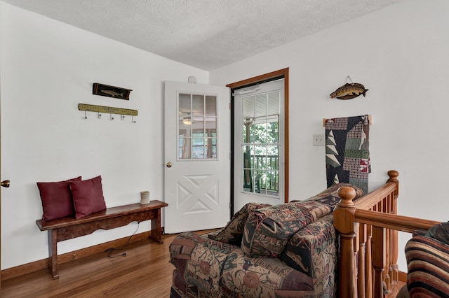 sitting room featuring wood-type flooring and a textured ceiling