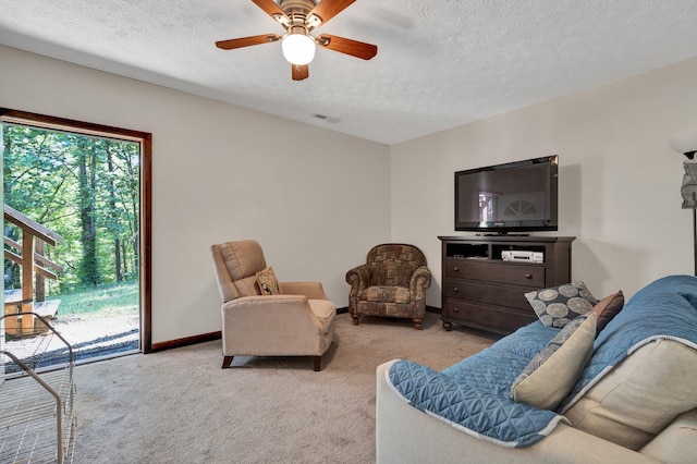 carpeted living room with ceiling fan and a textured ceiling