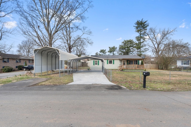 view of front of house with driveway, a porch, fence, a front yard, and a carport