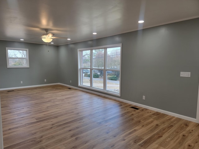 spare room with crown molding, ceiling fan, and wood-type flooring