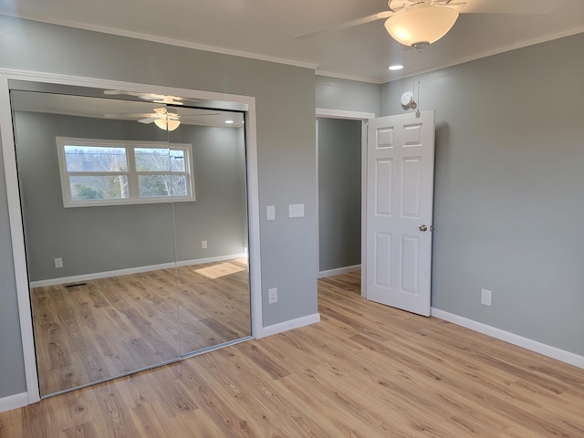 unfurnished bedroom featuring ceiling fan, ornamental molding, a closet, and light hardwood / wood-style flooring