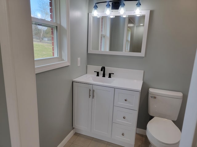 bathroom with vanity, a wealth of natural light, tile patterned floors, and toilet